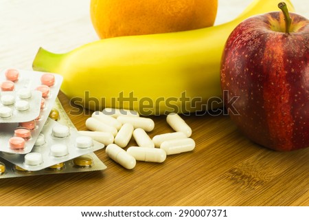 vitamin pills and various fresh fruits