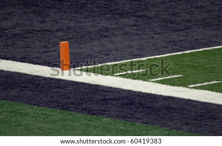 Corner of a football field blue end zone with orange pylon