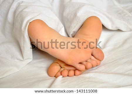 sleeping teen girl feet under the blanket