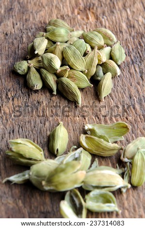Green Cardamom Pods on wooden background closeup