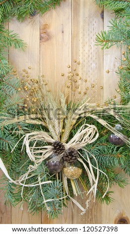Close up of the center piece of a Christmas wreath decorated with an agricultural theme on a wooden background