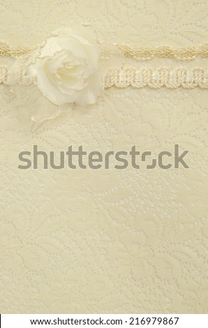 An old fashioned wedding or feminine background of lace with trim and a silk rose