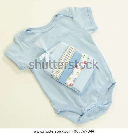 Generic baby onesie or jumpsuit and wash cloths on white in blues