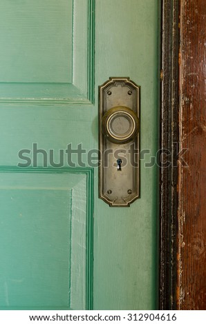 Vintage door handle and keyed  lock on a green door.