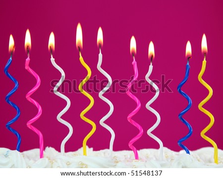Colorful birthday candles on purple background