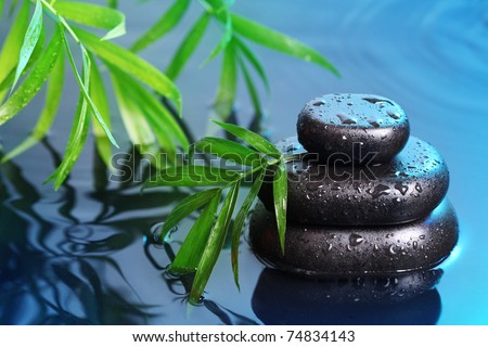Spa still life with stone pyramid reflecting in water