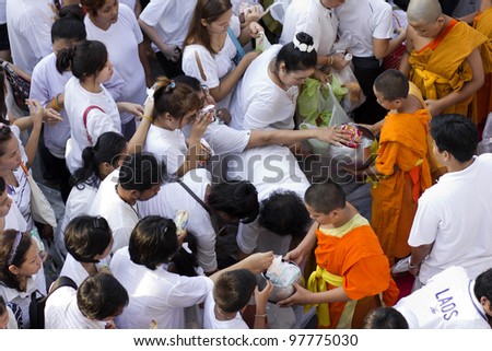 BANGKOK , THAILAND - MARCH 17: People give food offerings to a Buddhist monk on March 17, 2012 in Bangkok, Thailand. Thai traditional, people will make merit making by give food to monk