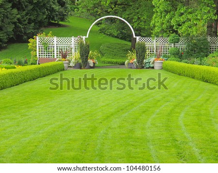 Outdor wedding place in the garden, with grass lawn and white arc