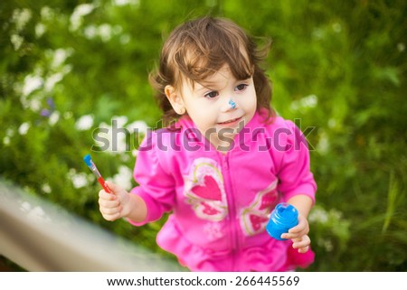 child painting hands outside