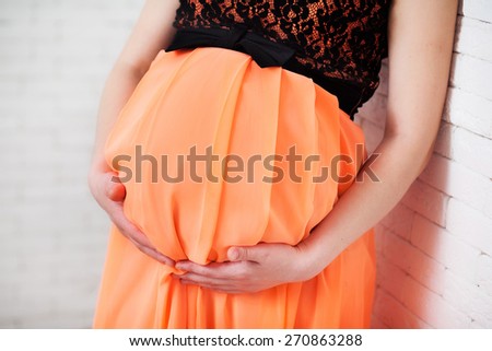 Image of pregnant woman touching her belly with hands. Pregnant woman caressing her belly.