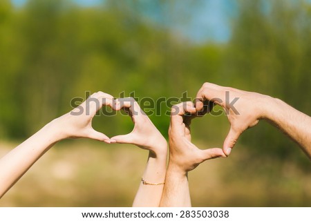 Hearts made by young couples hands. People in love.