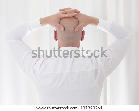 back of a bald-headed man in a white shirt