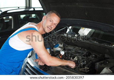 auto mechanic at service station working on a motor