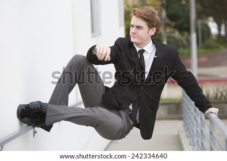 man in a suit jumping at a wall