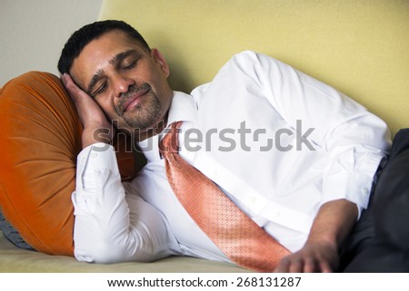 handsome businessman lying on couch and sleeping