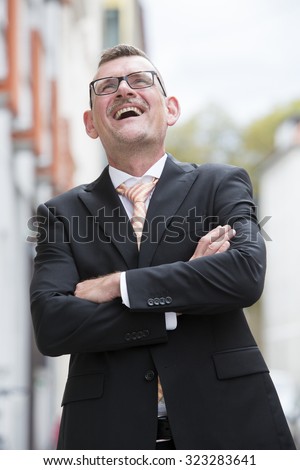 portrait of businessman standing in the street and laughing