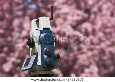 Spring Land Surveying - theodolite against blossoming tree