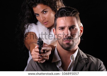studio portrait of a couple of criminals or detectives with a gun
