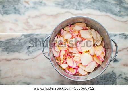 tin bucket filled with rose petals to throw at the wedding ceremony, top view shallow depth of field