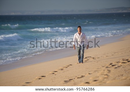 beautiful man walking alone in desert beach