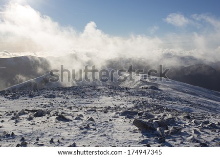 low cloud on snow covered mountain summit