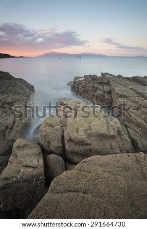 dawn at elgol with sea flowing round rocks on the shore