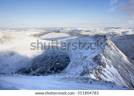mountain summit view in winter with snow and ice covered ridges, helvellyn, cumbria
