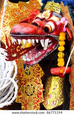 balinese dragon mask covered in gold and colors