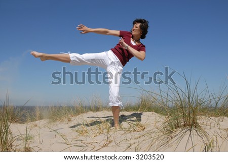 karate kick by a girl on the beach
