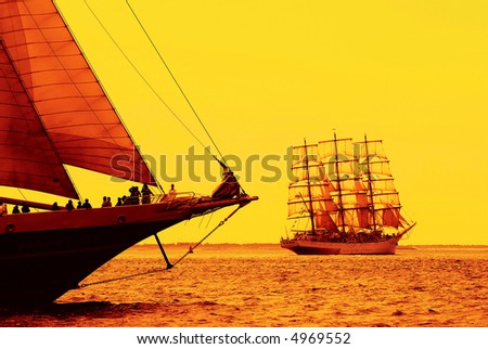 nostalgic sailboats sailing the ocean at sunset or sunrise