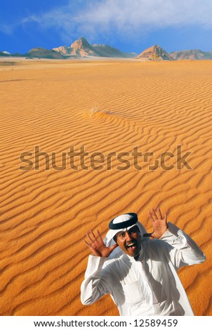 Traditional arabian man laughing, making funny face and playing peek-a-boo  in Wadi Rum desert, Jordan