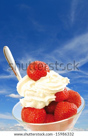 Summer dessert with fresh strawberries and whipped cream with blue sky background