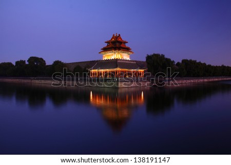 Palace turret at dusk with blue sky and colorful light reflection in water