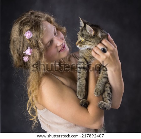 cute girl with roses in her hair and with a cat on his hands
