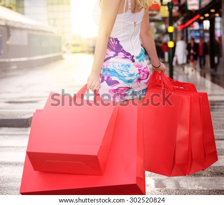 Shopping woman in sunset after rain
