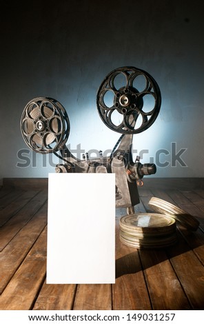 Movie projector with the film on the wooden floor