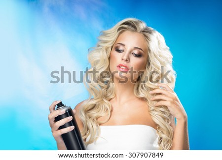 Beautiful young woman with a hair spray