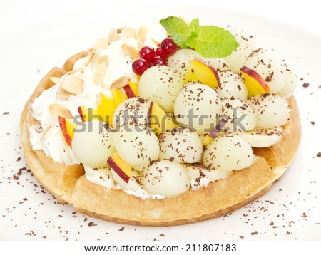 waffle with sweet melon balls, powdered sugar and peach