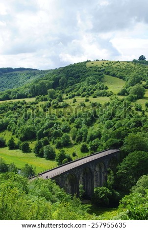 Stone arch bridge in green county side in the Peak District, UK