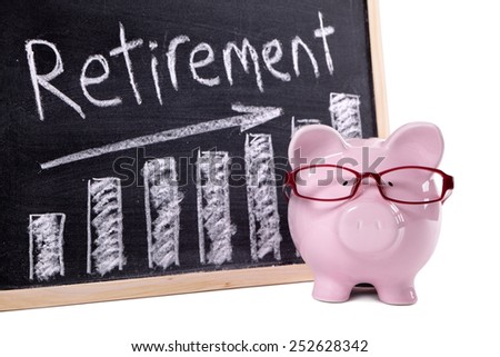 Retirement plan : Pink piggy bank with glasses standing next to a blackboard with retirement savings message.  Investment, growth, retire concept.