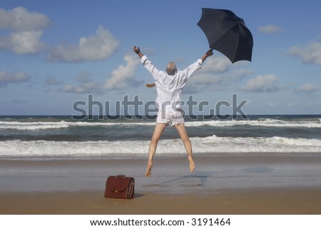 Senior business man jumping for joy on a deserted tropical caribbean beach.  Retirement freedom, escaping or vacation concept.  Copy space.