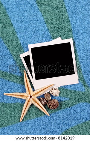 Beach background with beach towel, starfish, shells and blank instant photo prints