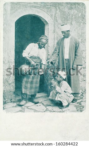ISTANBUL-Turkey,Circa 1900's :Ottoman people.Turkish man street water vendor. Child drinking water. Circa 1900's.