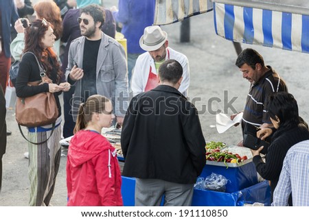 ISTANBUL - MAY 02: Turkish man sells deep fried fish to tourists at Eminonu on May 02, 2014 in Istanbul. Eating on the street is a part of local life in here.