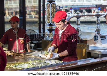 ISTANBUL - MAY 02: Turkish man sells deep fried fish to tourists at Eminonu on May 02, 2014 in Istanbul. Eating on the street is a part of local life in here. entertainment and travel of Istanbul.