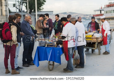 ISTANBUL - MAY 02: Turkish man sells deep fried fish to tourists at Eminonu on May 02, 2014 in Istanbul. Eating on the street is a part of local life in here.