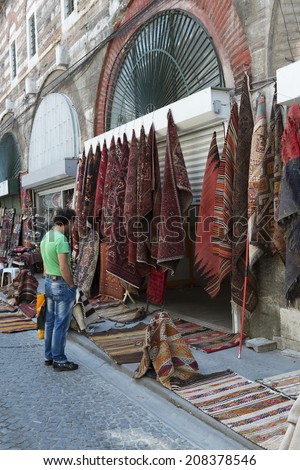 ISTANBUL, TURKEY - JUNE 30,2014:Colorful Handmade Carpets Displayed on the Street.Man looking at  carpet
