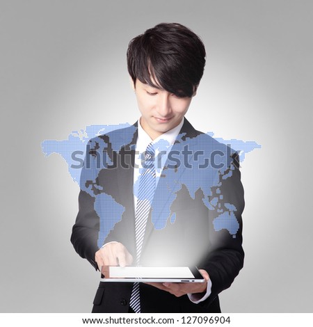 world in your hand - handsome business man using touch screen tablet pc, concept for business and cloud computing, asian man model