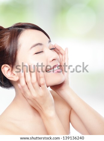 Relax woman closed eyes and finger point to eyes, concept for eye and skin care, isolated over nature green background, asian beauty