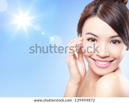 Beautiful woman face with sunshine and blue sky, concept for summer skin care and sun block, asian beauty